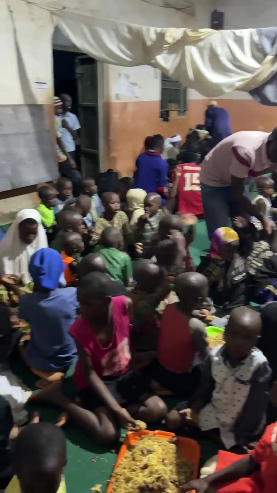 Kinder sitzen beim Iftar auf dem Boden der Moschee